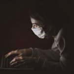 Woman wearing mask uses laptop for medical appointment. // Image from Pixabay