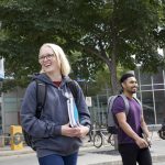 Two smiling students walk on the Bannatyne campus