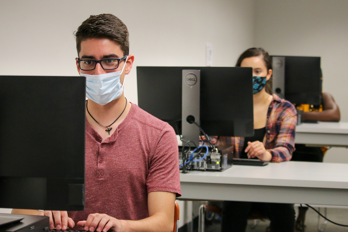 Students wearing masks work on computers