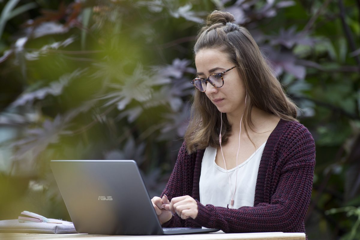 A student works on a laptop on the UM campus