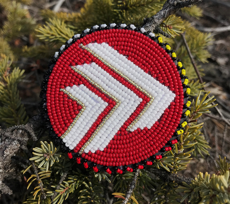 Beaded asper pin, with yellow, black, red and white around the outside.