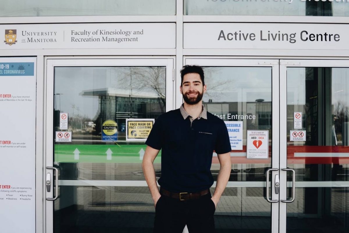 Bryden Bukich stands in front of UM's Faculty of Kinesiology and Recreation Management