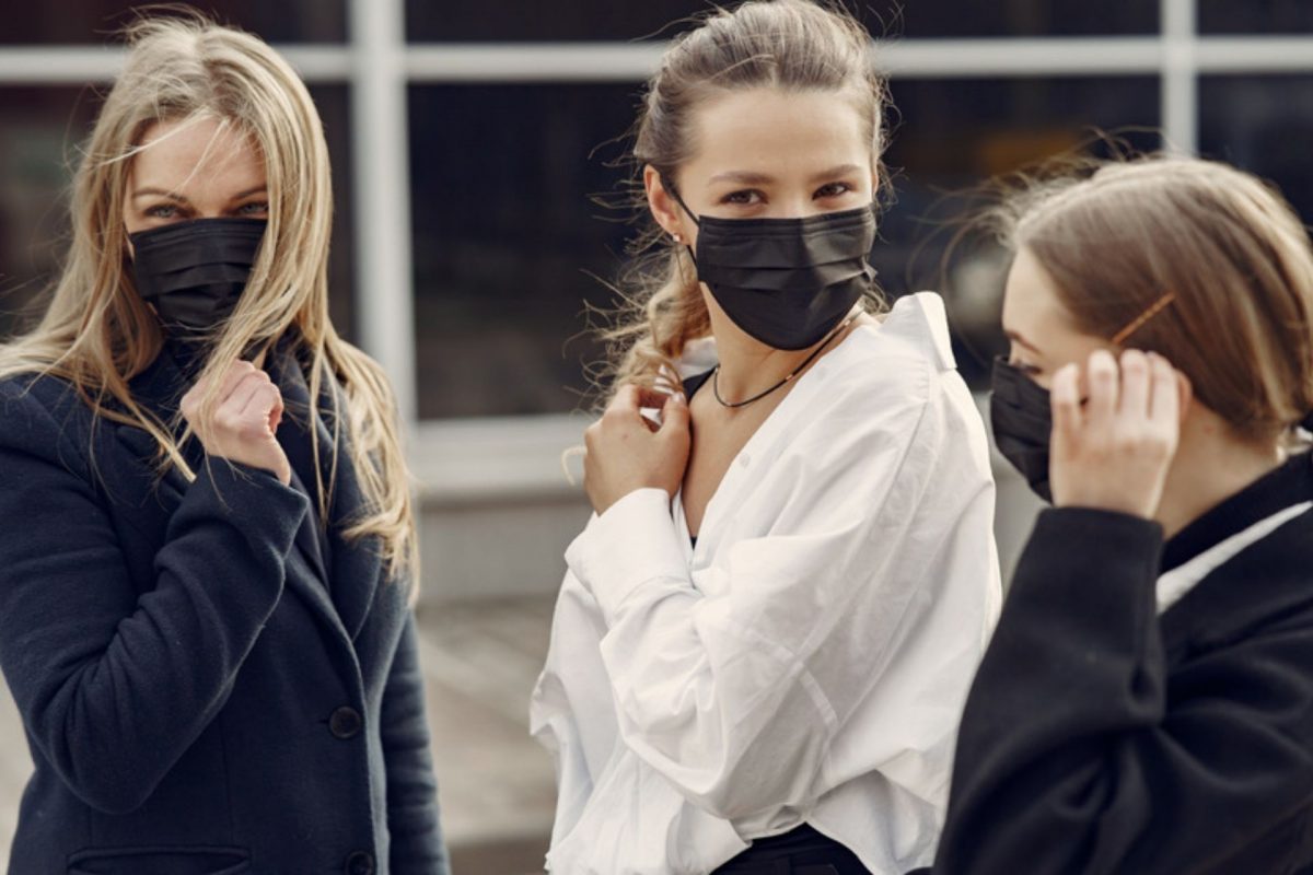 Three girls wear face masks.