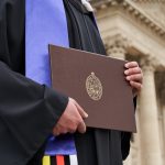 Person in grad gown holding degree