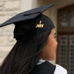 A student wears a graduation cap and on the tassel is 2021.