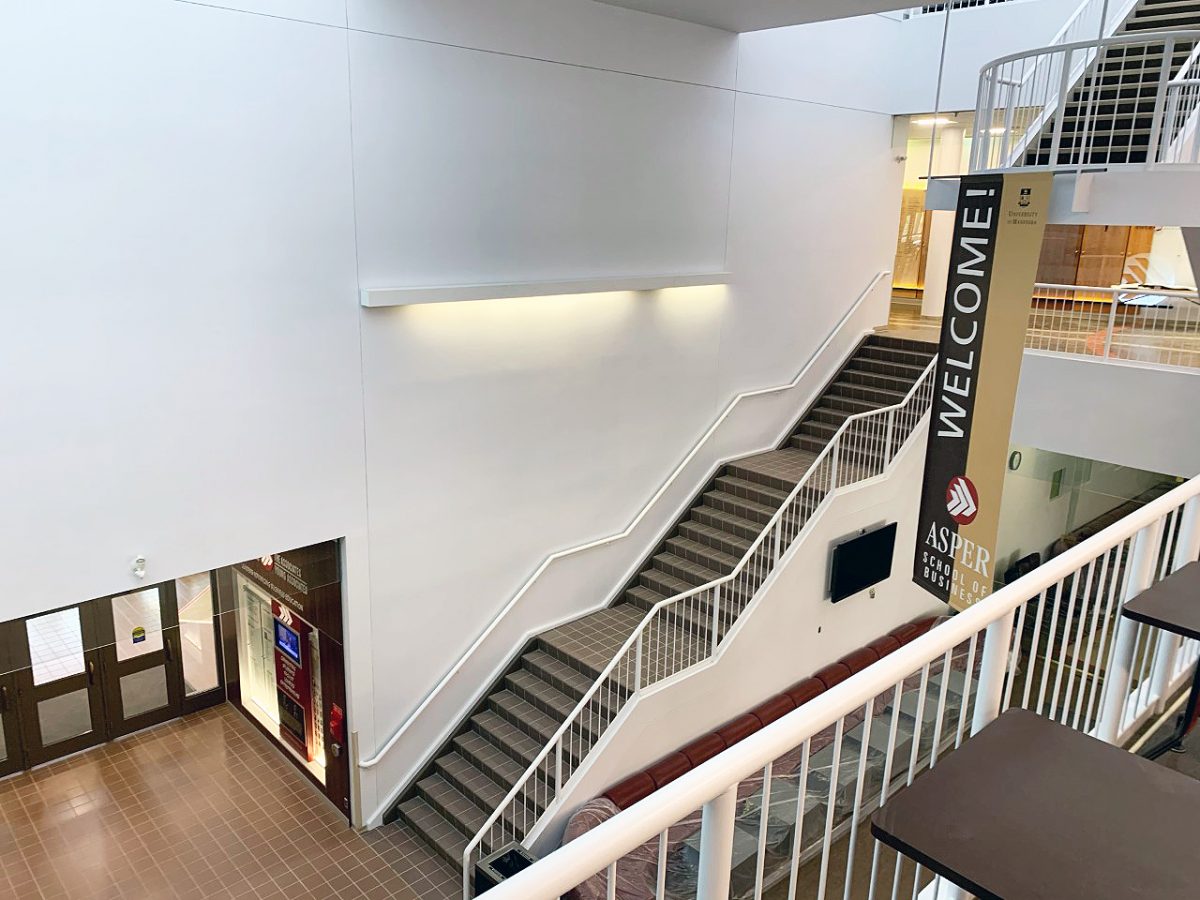 Birds eye view of a black and white staircase in the Asper School Drake building.
