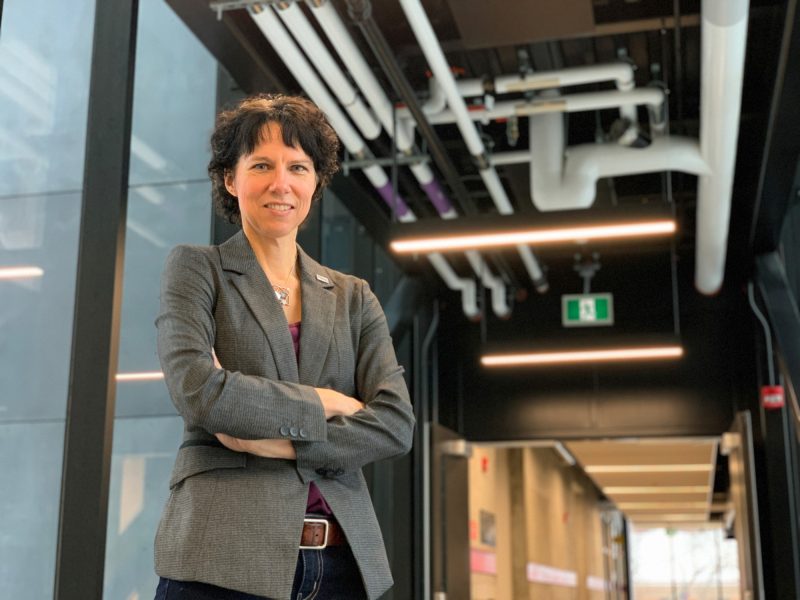 Dean Marcia Friesen stands posing and smiling for the camera.