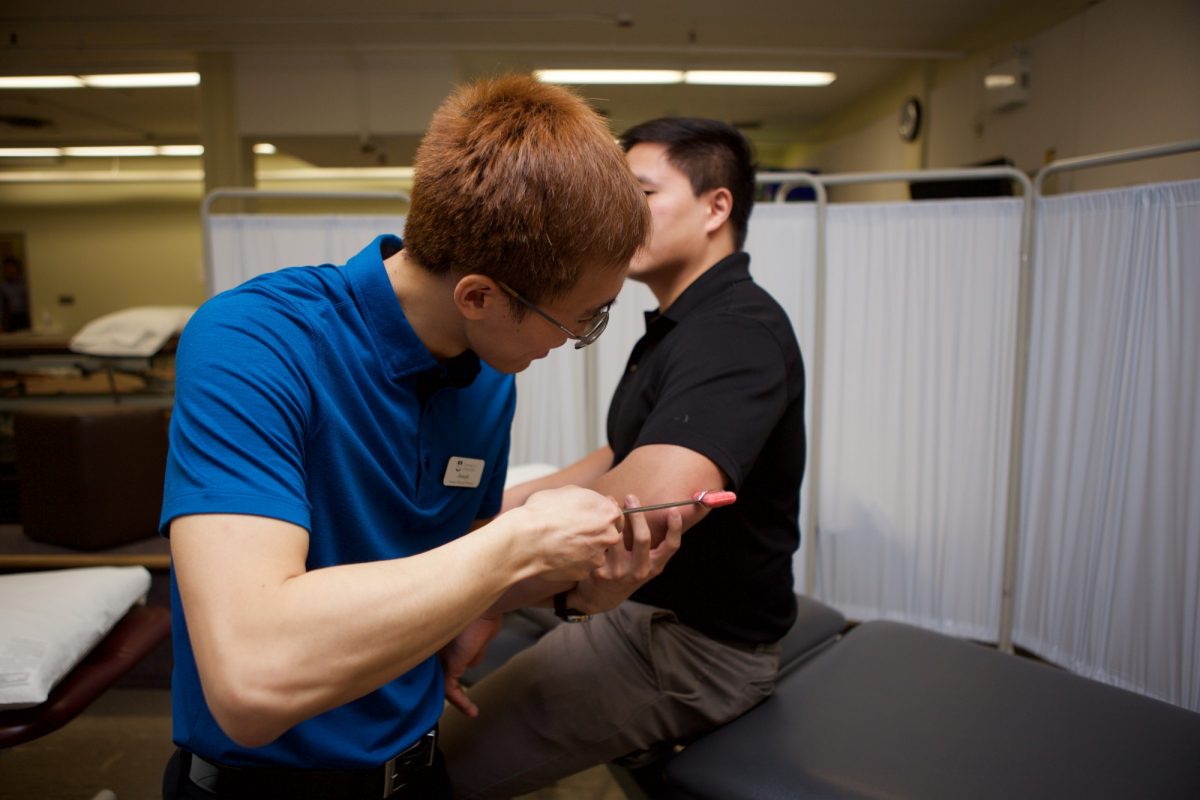 A UM physical therapy practices orthopedic skills in a lab.