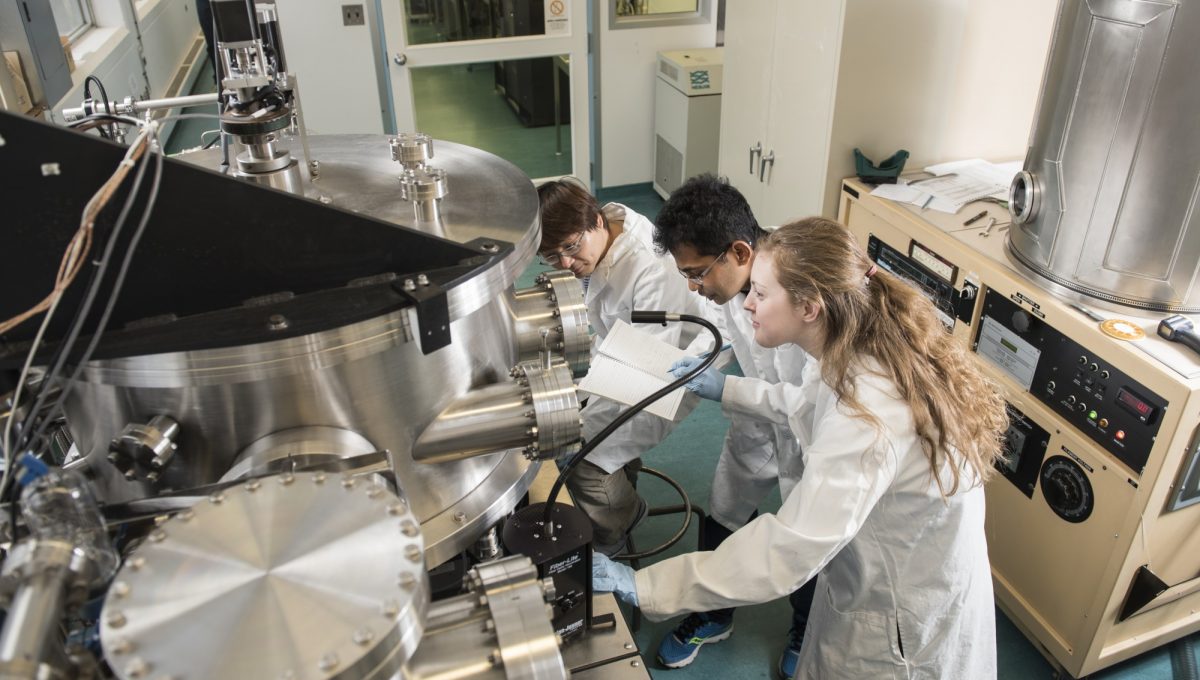 three students working on equipment in nanofab lab
