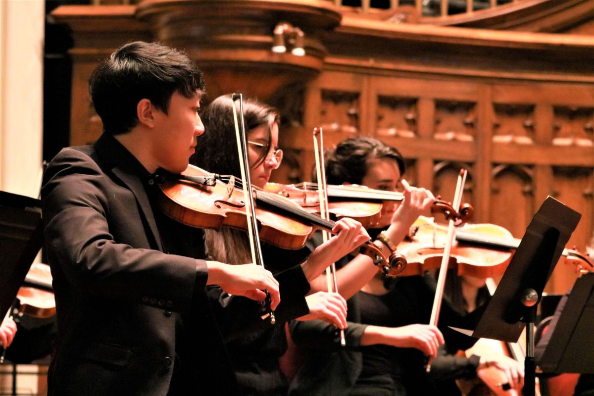 music student playing violin with ensemble