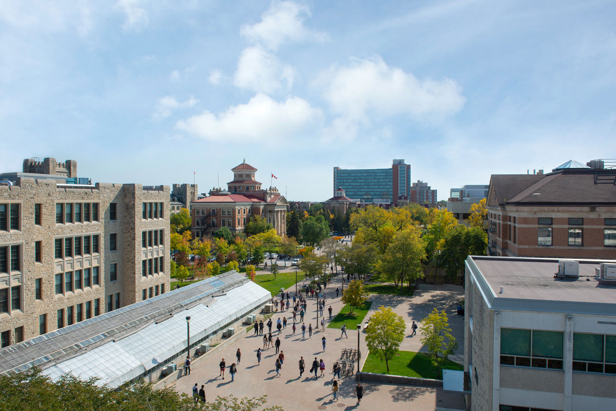 An aerial image of Fort Garry campus, looking south was people walk below.