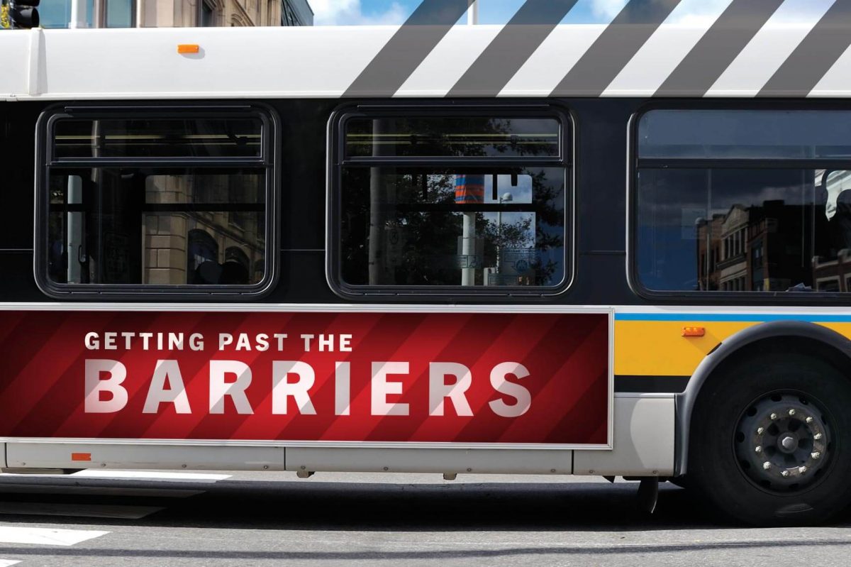 A public transit bus with a red advertisement on the side that says "Getting past the barriers" on it.