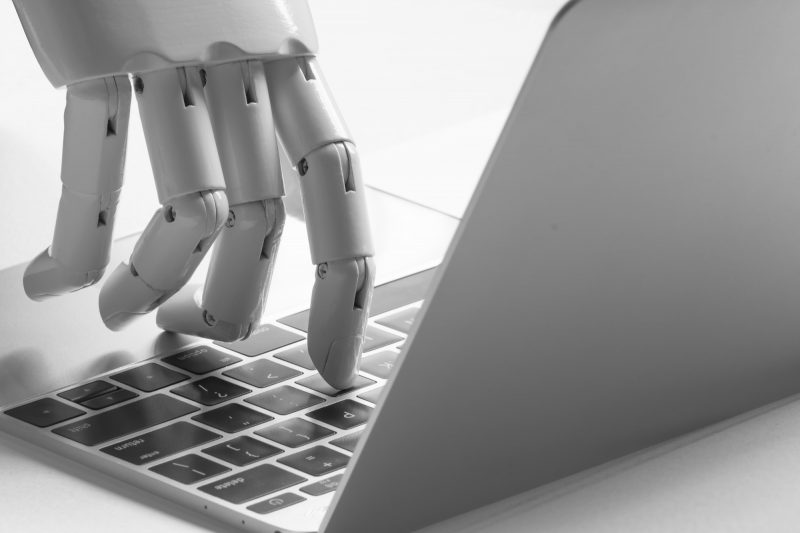 Robot hand types on laptop