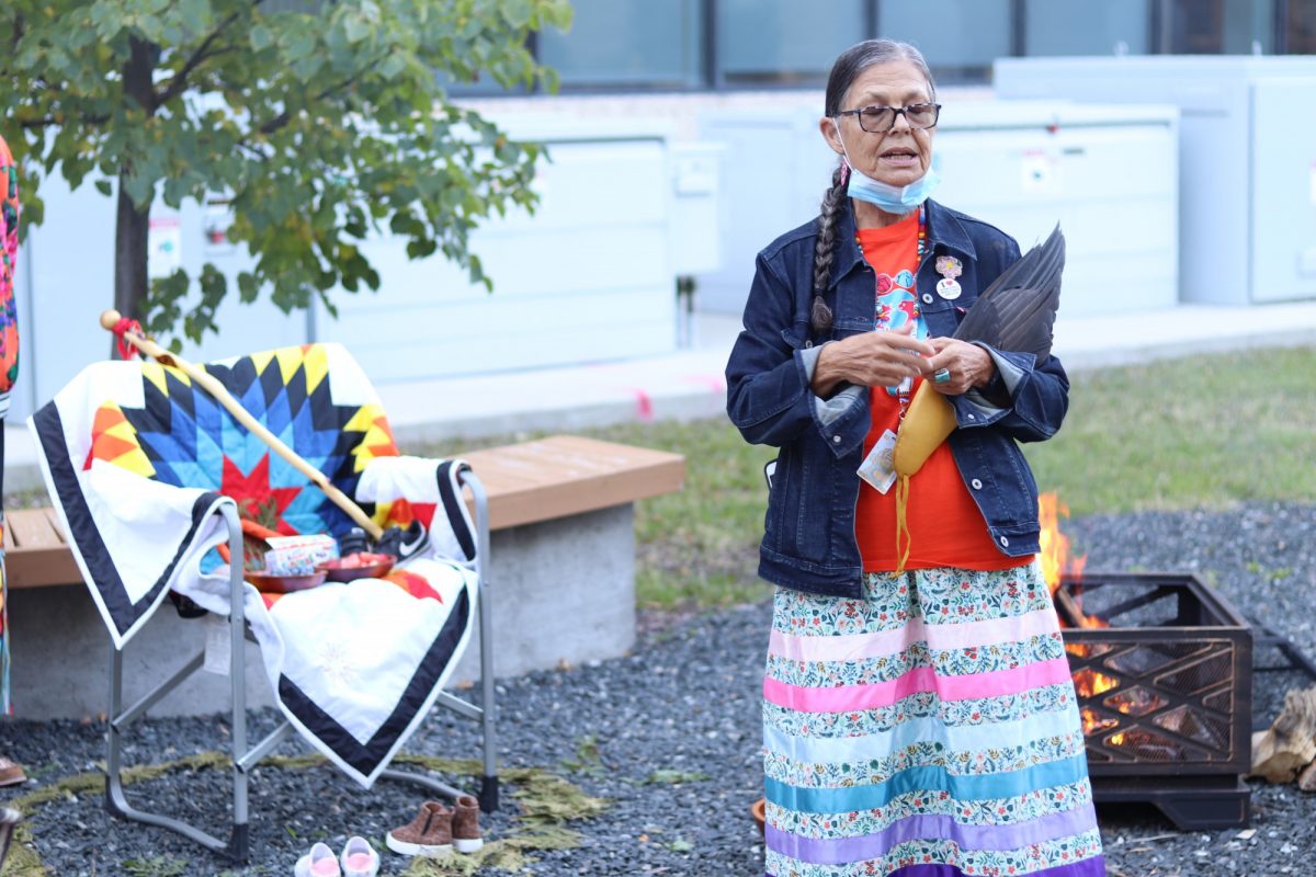 Knowledge Keeper Leslie Spillett speaks near the sacred fire and spirit chair at the Honouring Our Children ceremony.