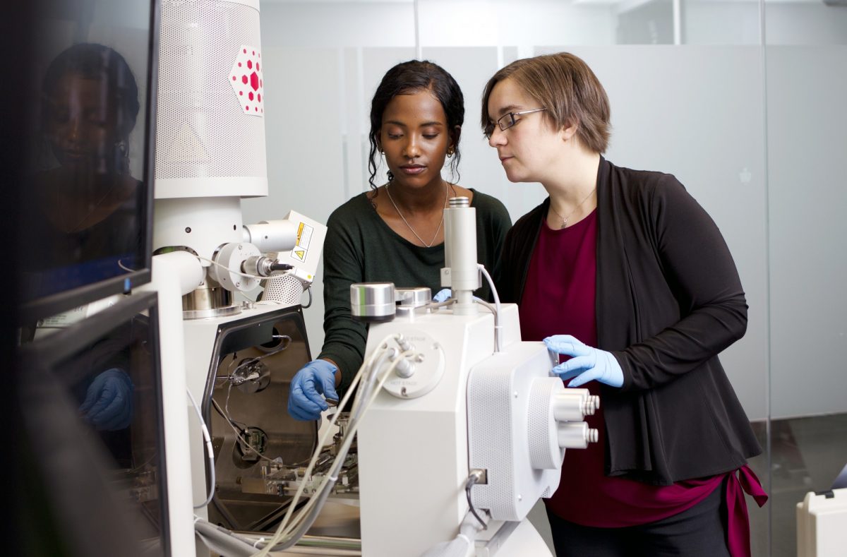 two female researchers setting up a specialized microscope