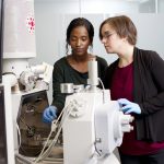 two female researchers setting up a specialized microscope