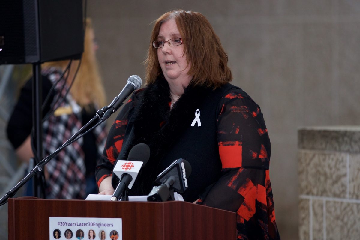 Ruth Eden stands at a podium speaking during the 2019 ecole polytechnique memorial service.