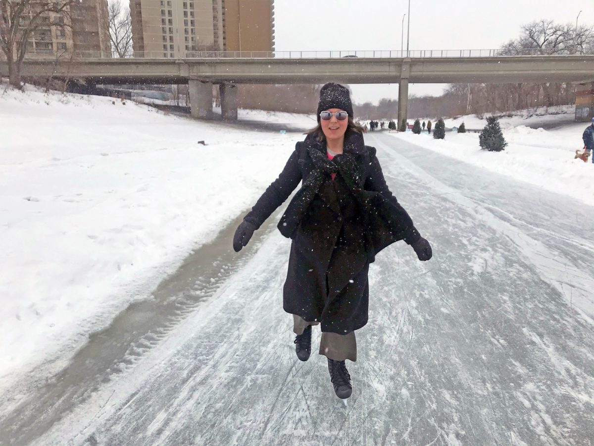 Asper School of Business alumna, Sara Stasiuk, walking on The Forks river trail, smiling.