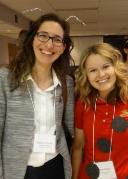 Two smiling women stand side by side