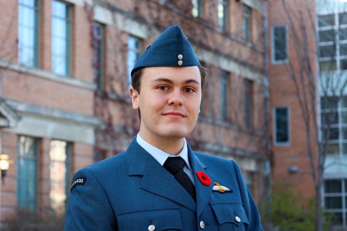 Dominic Donato stands smiling, posing for the camera wearing a Royal Canadian Air Force uniform with a poppy.