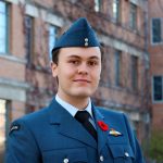Dominic Donato stands smiling, posing for the camera wearing a Royal Canadian Air Force uniform with a poppy.