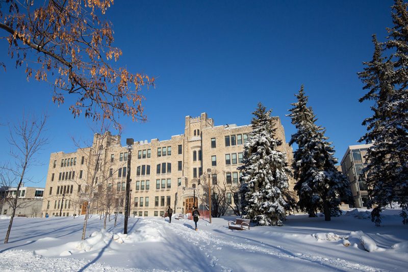 Students walking on Fort Garry campus in winter, near Buller Building.