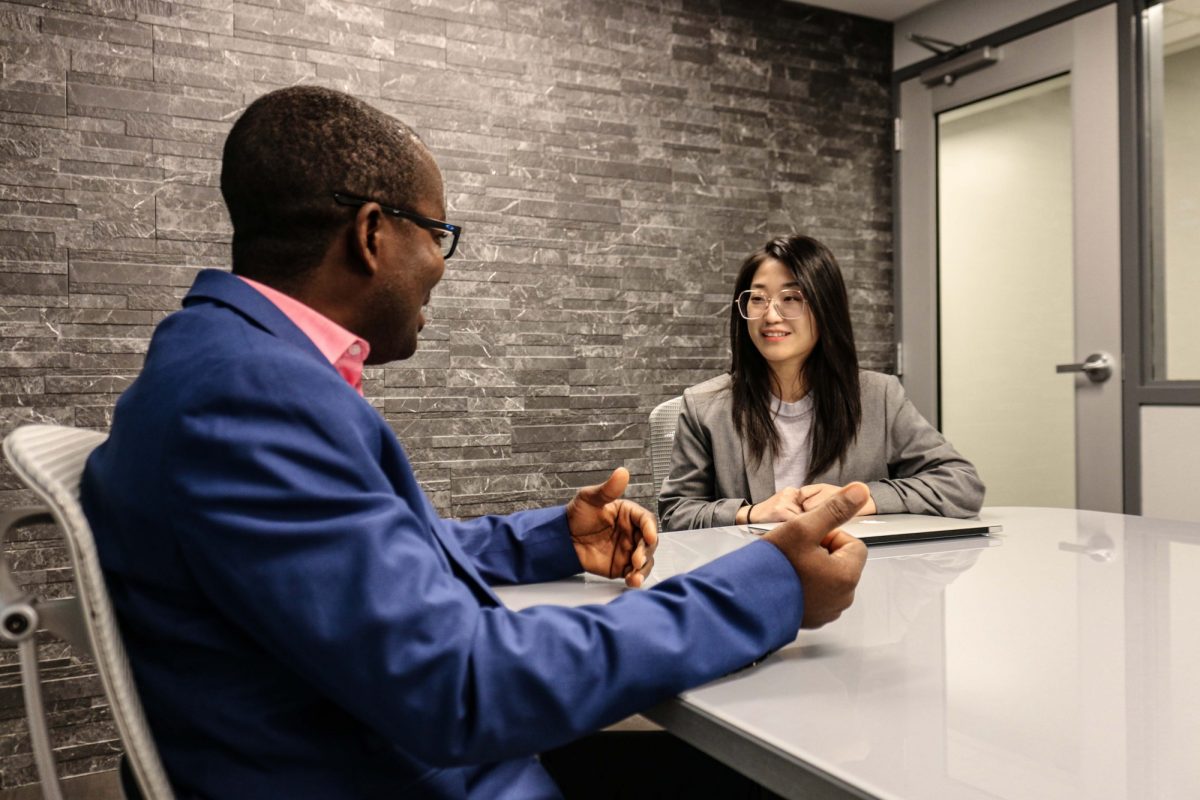 Asper co-op advisor sitting with a student in a board room at the Asper School of Business.