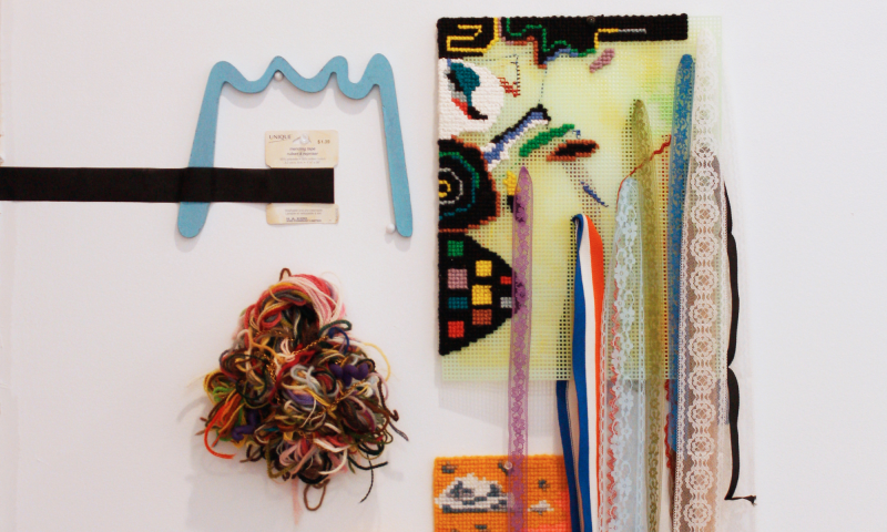 Lauren Prousky, The inherent cost of line that hugs, 2020, yarn, plastic canvas, chains, finger puppet, hemming, acrylic, wood, and mending tape. Originally exhibited at the Museum of Jewish Montreal, 2021. Photo: Karice Mitchell.