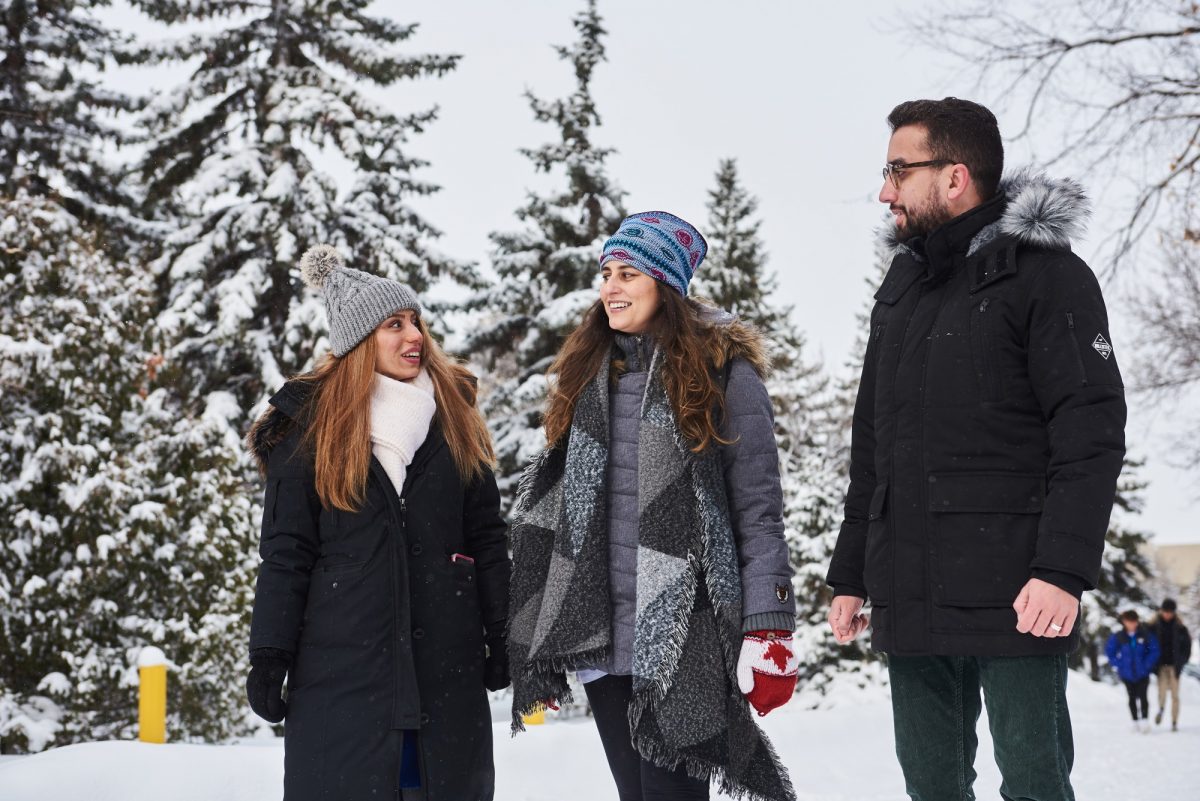 Three international students outside in winter.