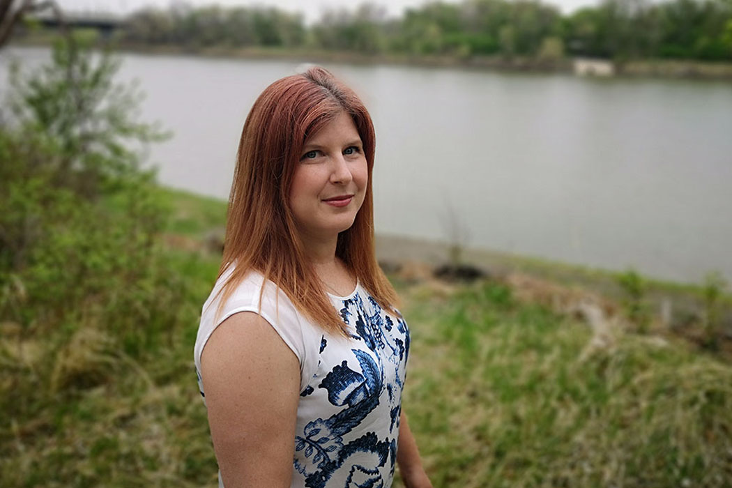 Genevieve Thompson poses by a river.