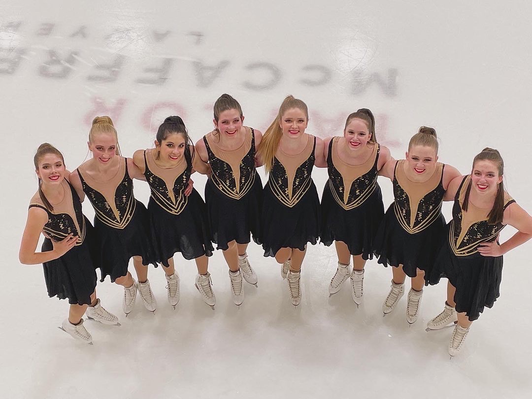 Members of Ice Intrepid stand in a semi circle on the ice smiling