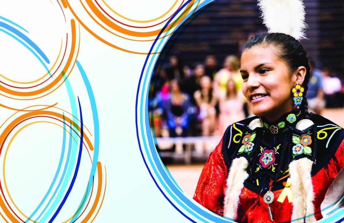 An Indigenous woman in regalia smiles
