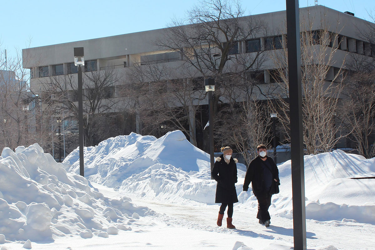 Two people walk outside UMSU University Centre in winter 2022 on Fort Garry campus. // Photo by Jack Rach