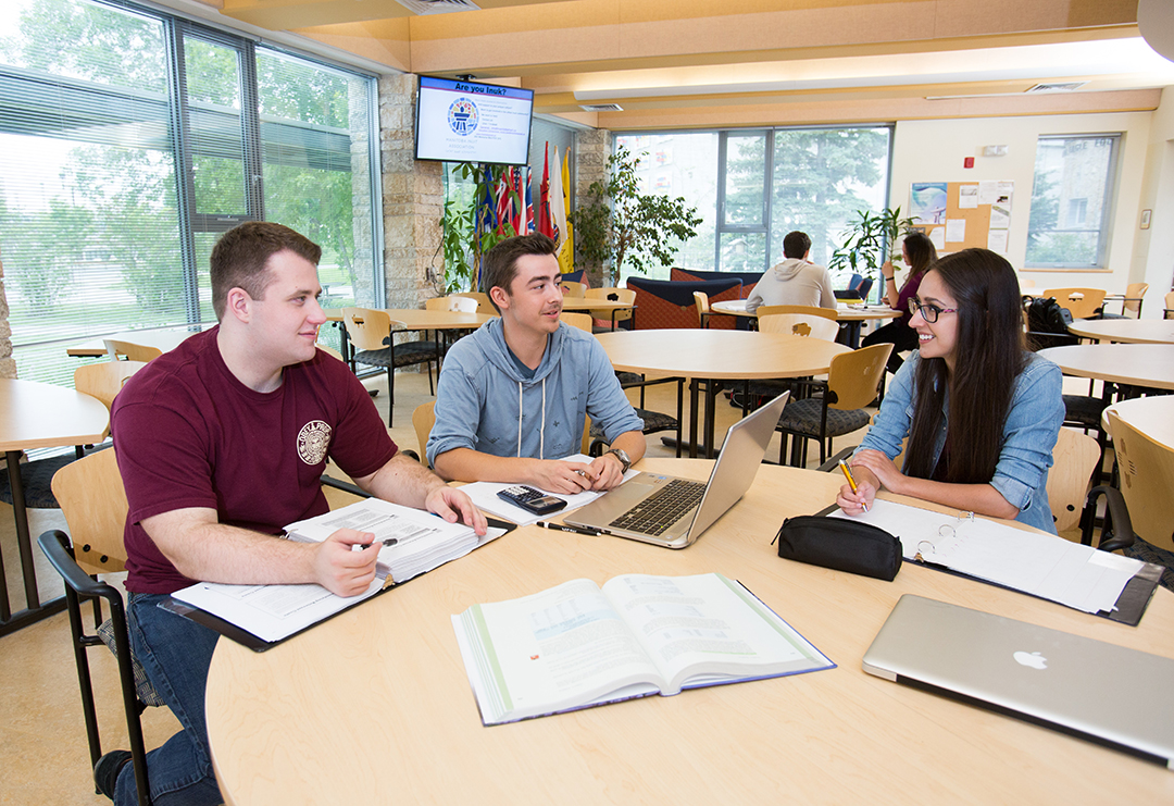 Three students studying at a table together.