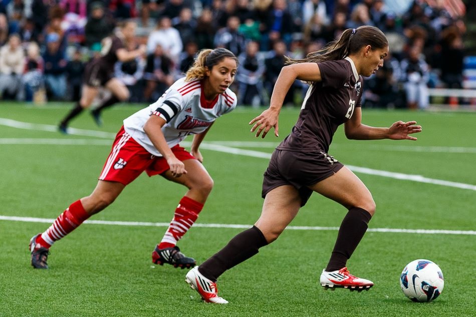 Bruna, in a Bisons jersey, runs with the ball