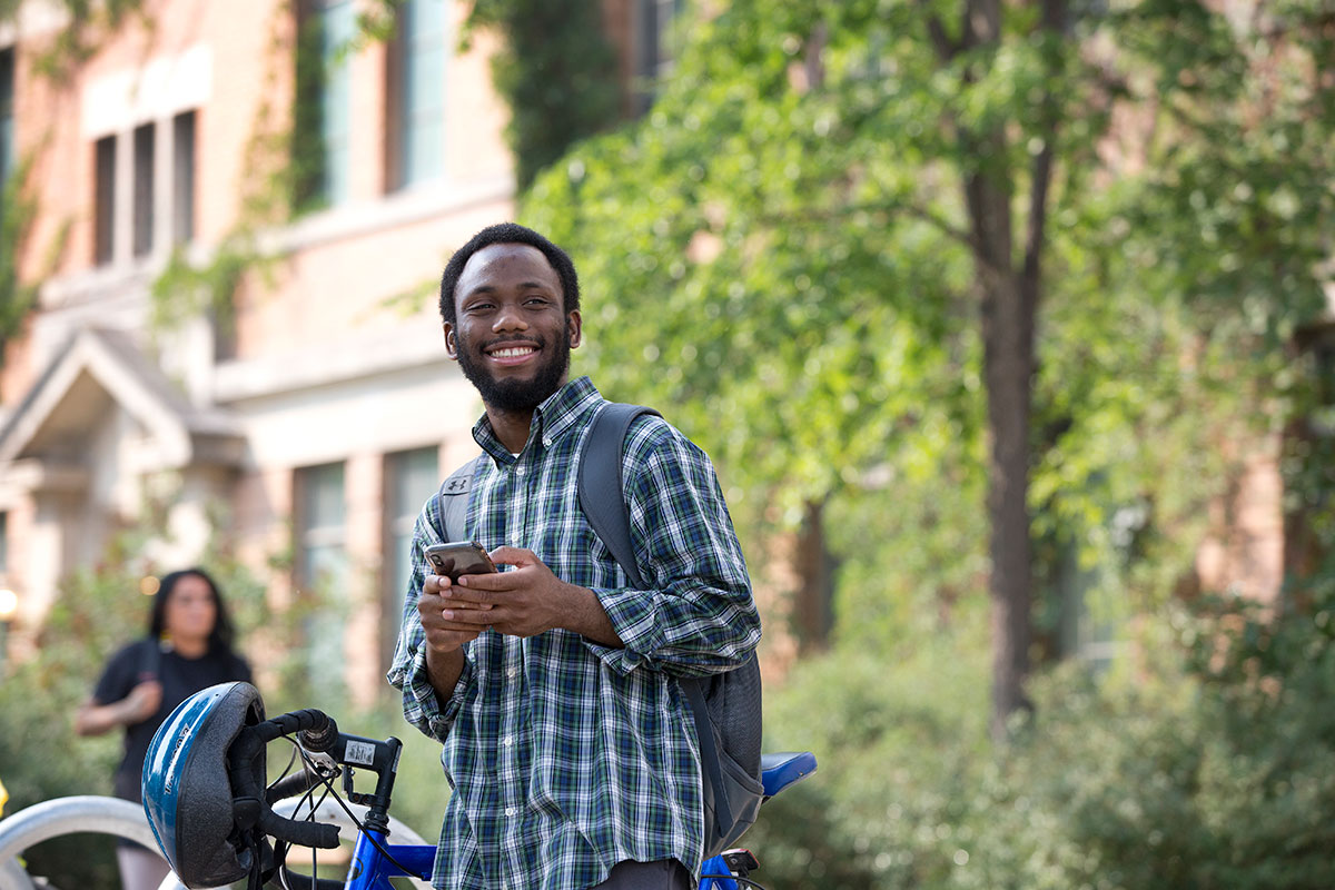 An international student standing outside on campus.