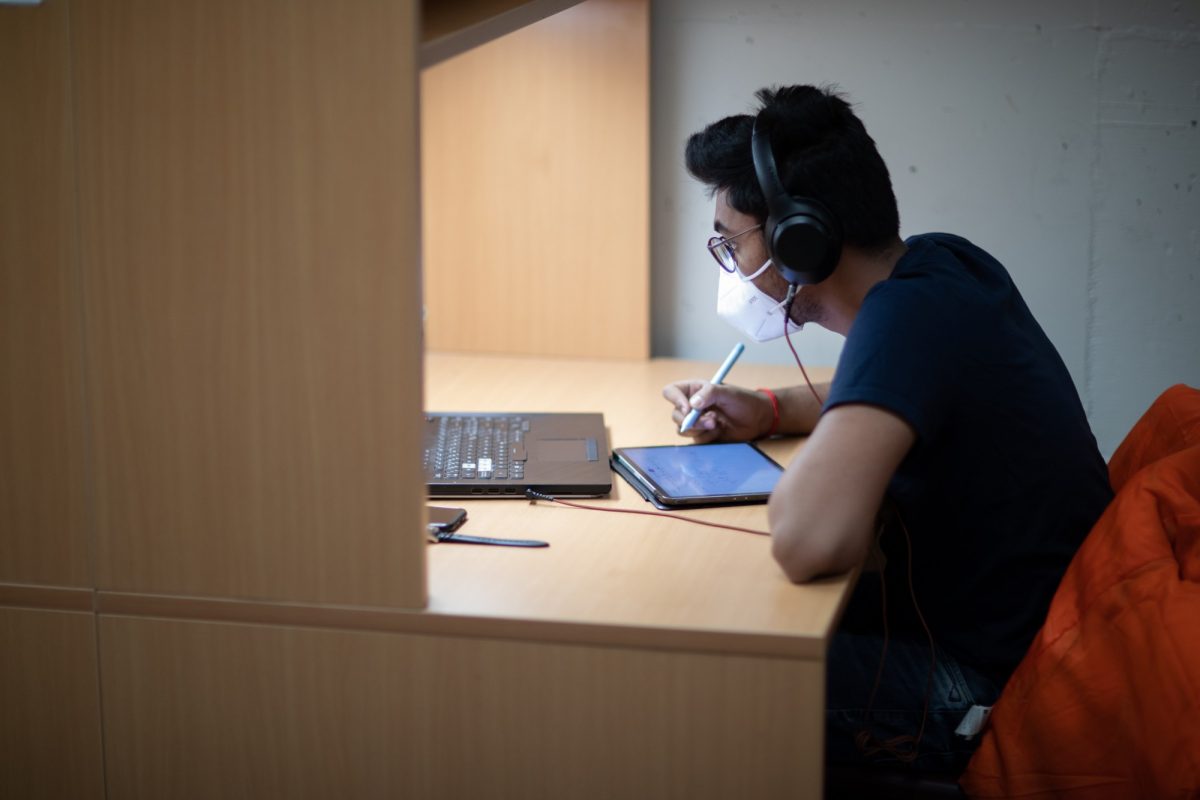 Student in mask studies for exam