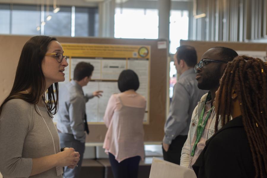 A presenter discusses their research at a previous Research Day
