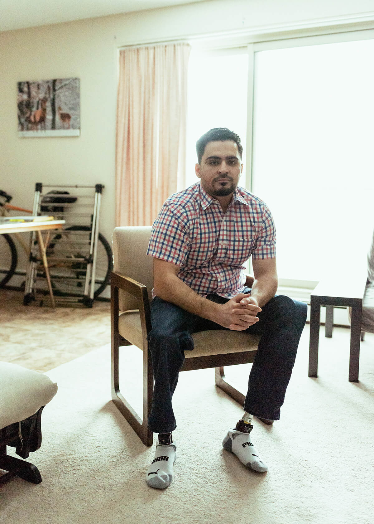 Ameen sits in a chair in a living room.