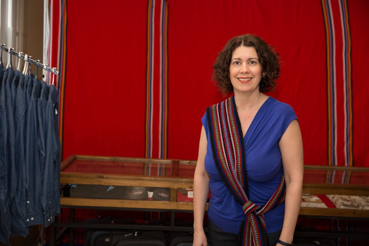 Michelle Driedger wearing a Metis sash in front of a red background