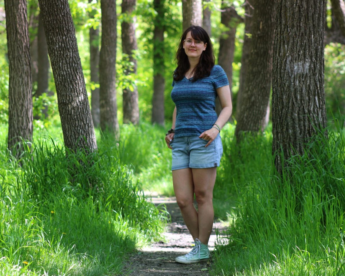 Entmology MSc student Crystal Almdal stands on a forest path.