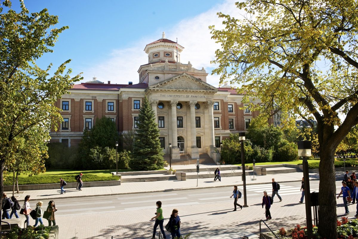 The admin building on UM's Fort Garry Campus on a summer day. Students are milling in the foreground