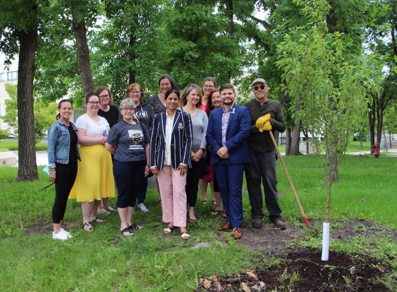 Members of the Support Staff Endowment Fund Committee stand near the newly planted tree on UM's Fort Garry campus.