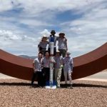 The U M S A T S rocketry team standing in front of their rocket in New Mexico.