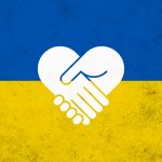A Ukrainian flag superimposed with two hands shaking in the form of a heart.