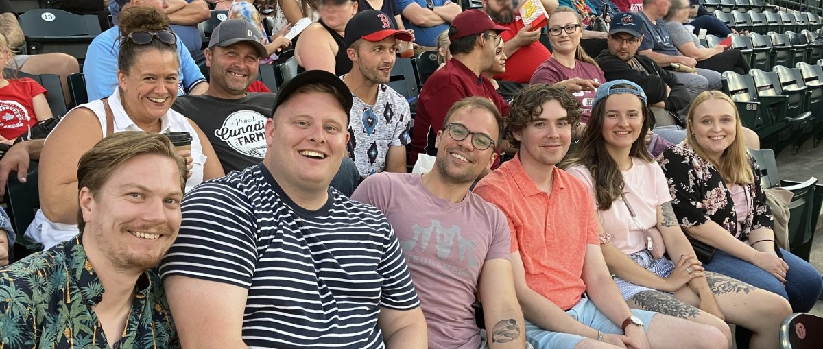 A photo of a row of smiling law students at the Goldeyes baseball game.