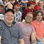 A photo of a row of smiling law students at the Goldeyes baseball game.