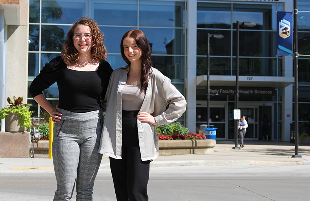 Student researchers Catherine Campos and Samantha Prokopich stand outside the Brodie Centre at Bannatyne campus.