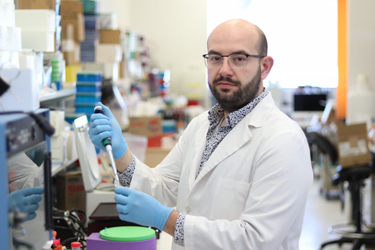 Berardino Petrelli, wearing a lab coat and gloves, working in the research lab.