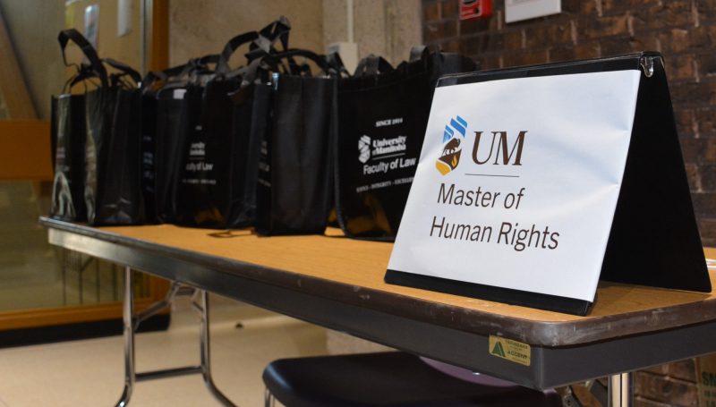 a table with bags and a sign on it that says UM Master of Human Rights program